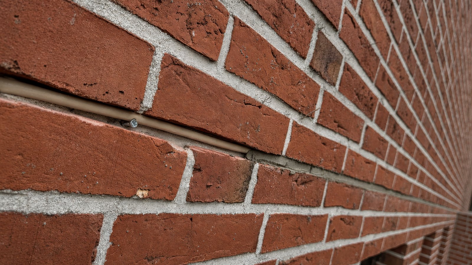 Netzwerkkabel unsichtbar in der Mörtelfuge einer Klinkerwand verlegt